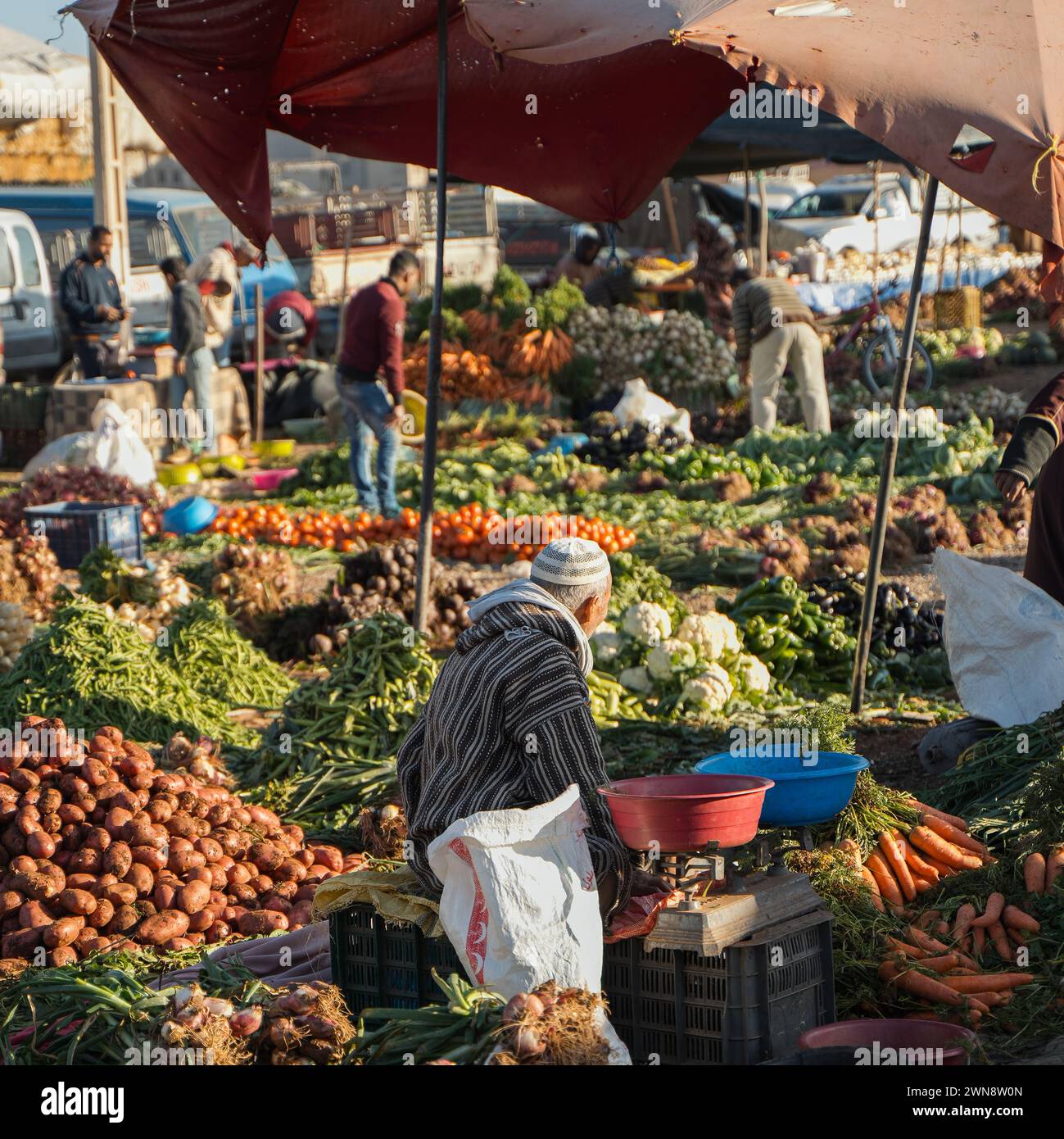 Homme de derrière vendant des légumes et des légumes verts dans le marché souk en plein air Banque D'Images
