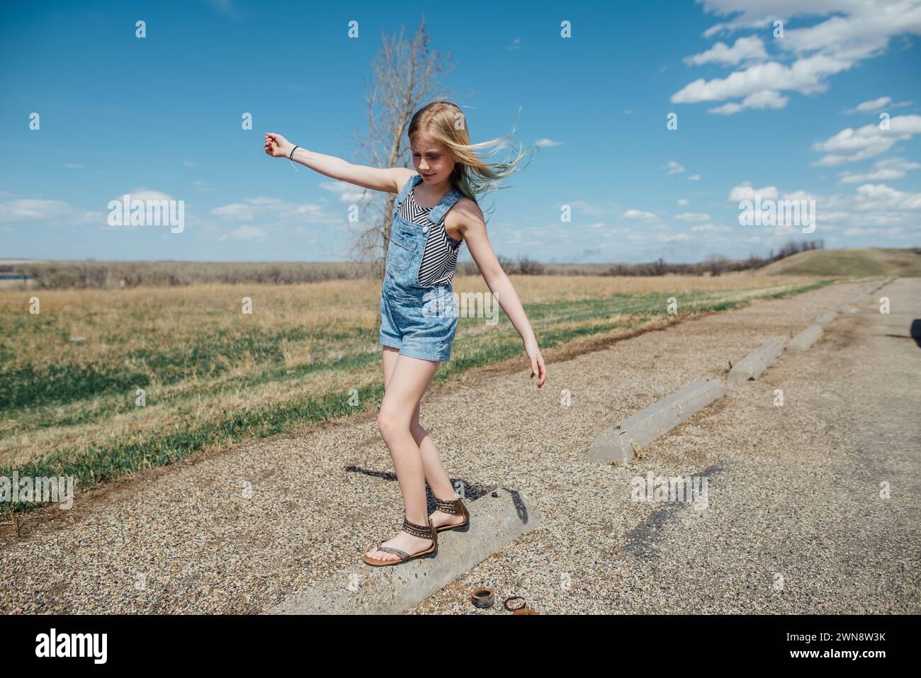 Teen Girl équilibre sur l'objet dans la campagne en été. Banque D'Images