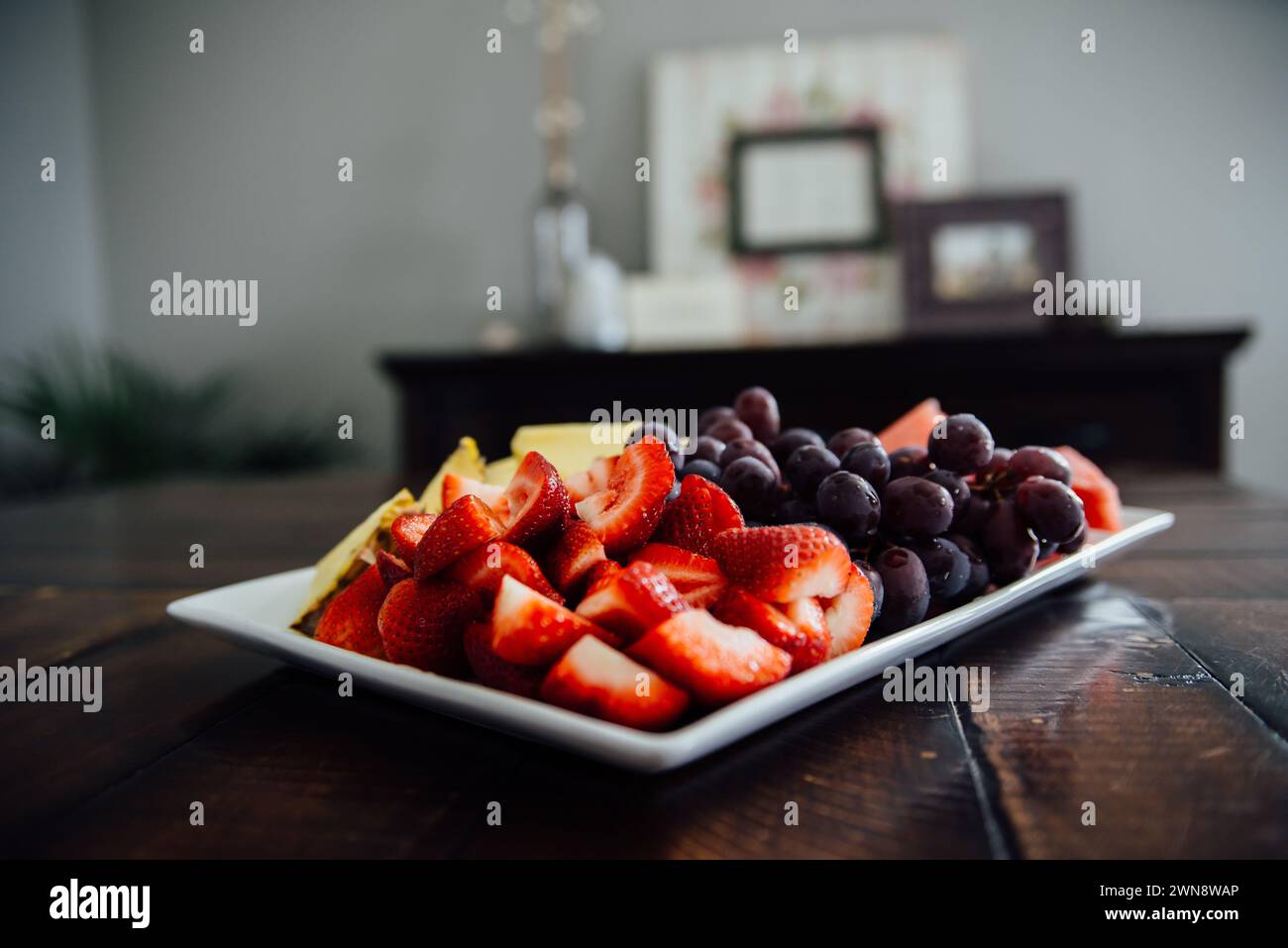 Vue de détail de côté de l'assiette de fruits sur la table à la maison. Banque D'Images