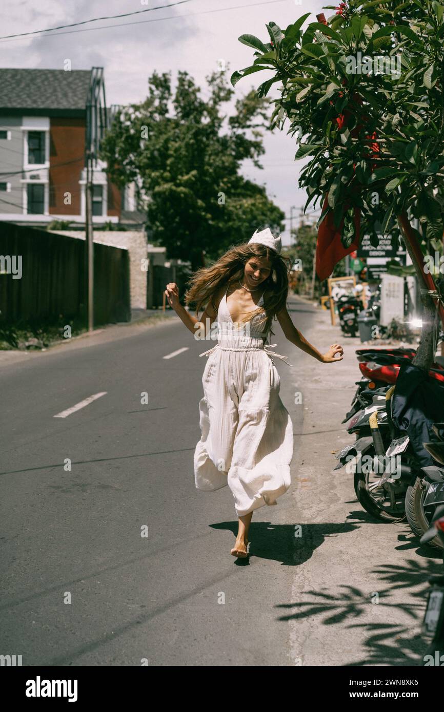 Une jeune femme aux cheveux longs descend la rue à Bali. Banque D'Images