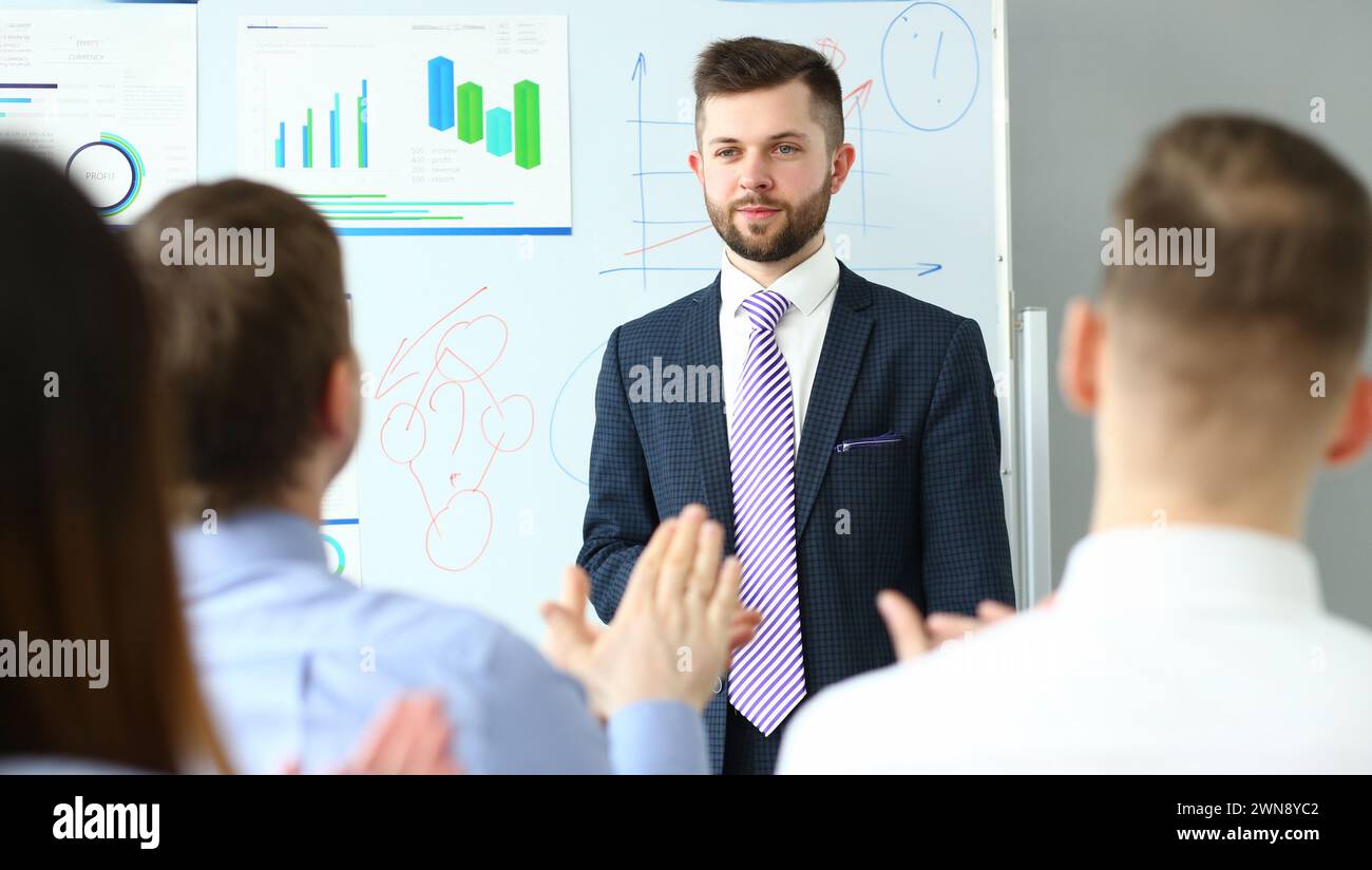 Groupe de personnes écoutant l'homme dans le costume et l'égalité de dire quelque chose Banque D'Images