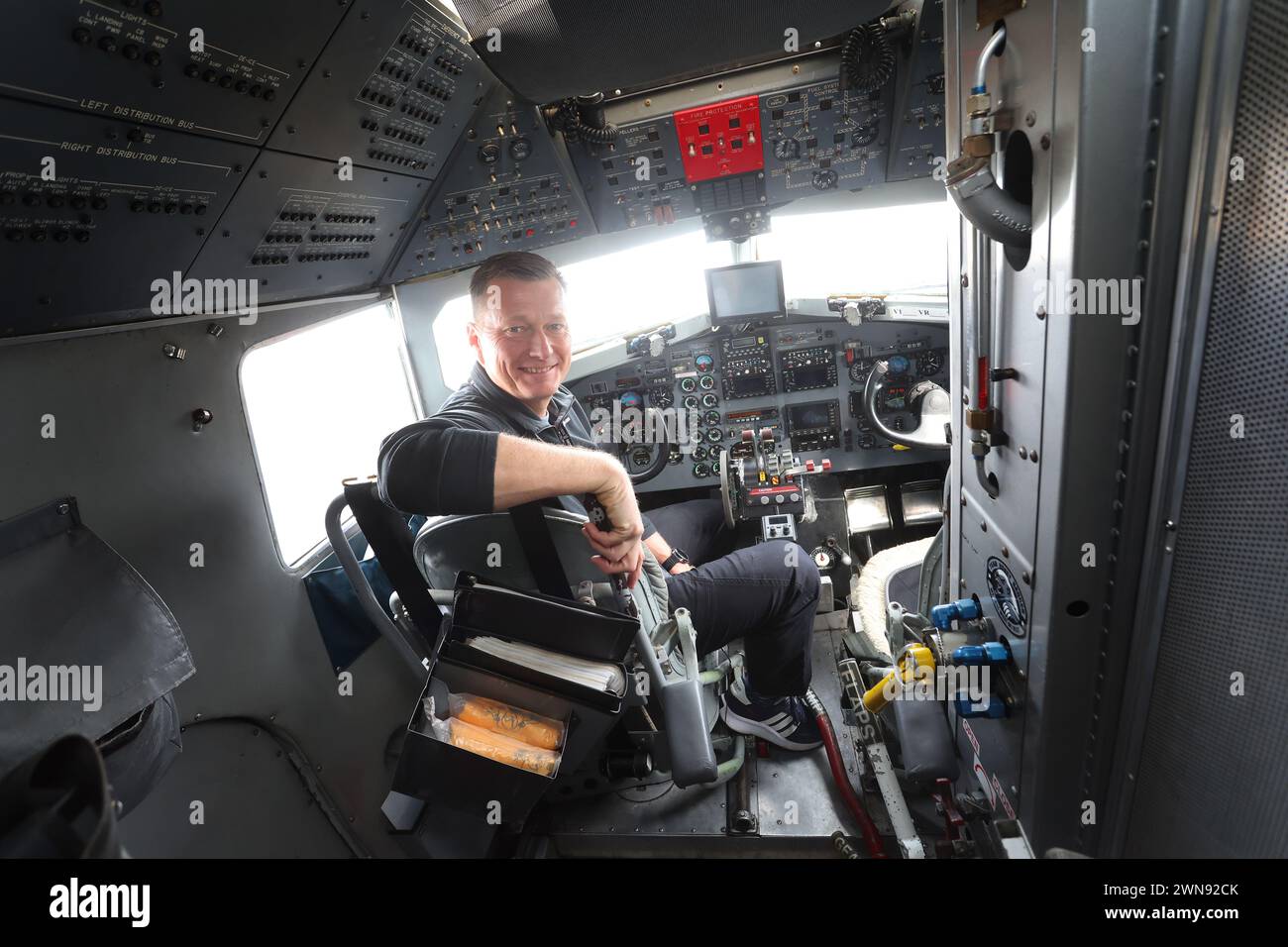 Giebelstadt, Allemagne. 01 mars 2024. Andrew Searle, directeur de vol de Bell Geospace Limited, est assis dans le poste de pilotage d'un Douglas DC-3 converti de 1943 à l'aéroport de Giebelstadt. L’avion, équipé de la technologie de mesure la plus récente, sera utilisé dans les semaines à venir pour collecter des informations géophysiques sur les propriétés de la roche souterraine dans les régions de Würzburg et de Nuremberg afin d’explorer le potentiel d’utilisation d’une énergie géothermique respectueuse de l’environnement. Crédit : Karl-Josef Hildenbrand/dpa/Alamy Live News Banque D'Images