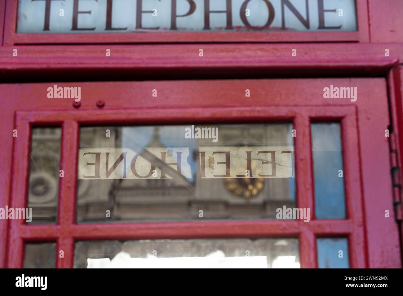 Westminster reflété dans la fenêtre de la cabine téléphonique. Banque D'Images