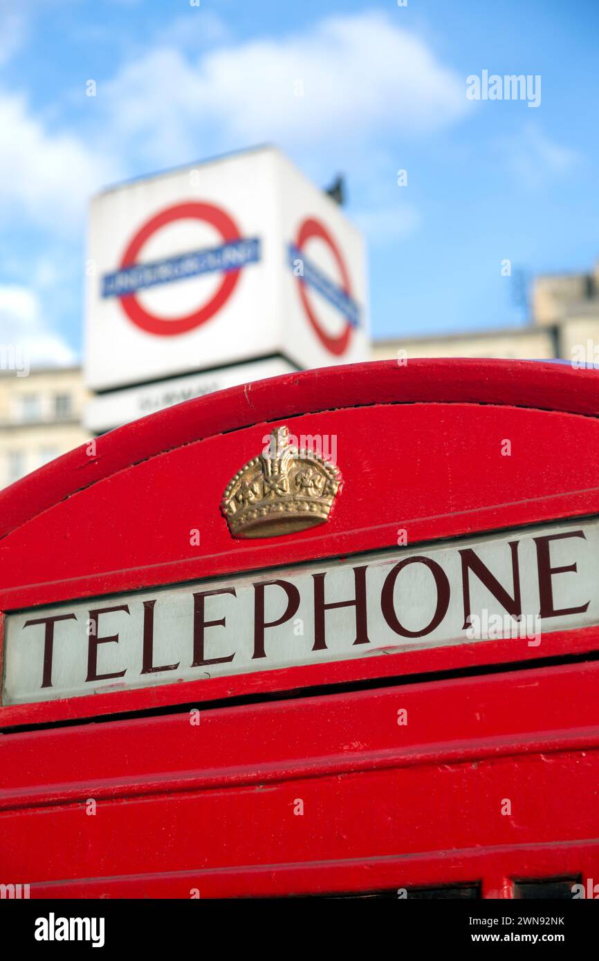 Téléphone rouge et panneau métro de Londres. Banque D'Images