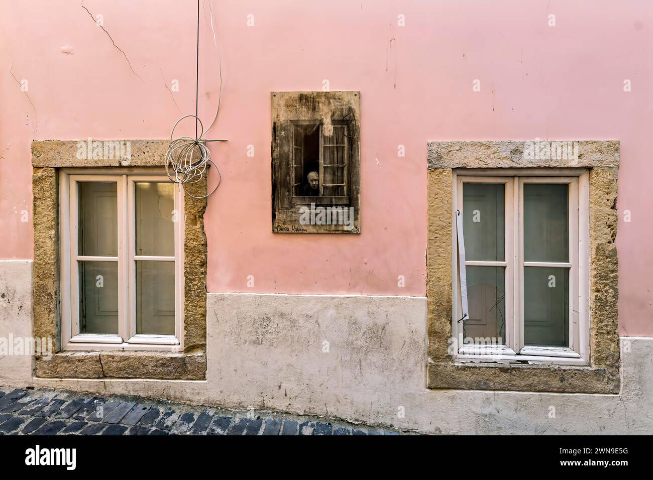 Façade d'un ancien bâtiment avec des murs rose pastel et des fenêtres en pierre avec volets en bois fermés, Alfama, Lisbonne Banque D'Images