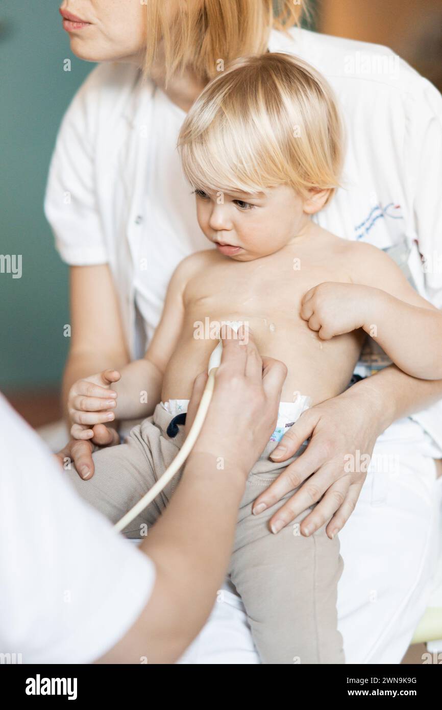 Petit enfant étant examiné pour le souffle cardiaque par l'examen d'échographie cardiaque par cardiologue dans le cadre du contrôle médical régulier au pédiatre Banque D'Images