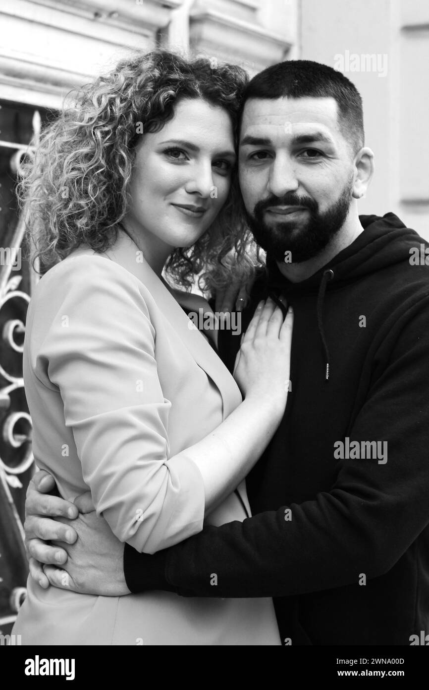 Couple serrant devant la vieille porte souriante Banque D'Images