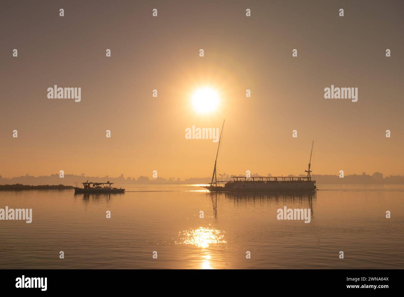 Silhouette d'un bateau traditionnel égyptien dahabiya naviguant sur le Nil au coucher du soleil, Egypte Banque D'Images