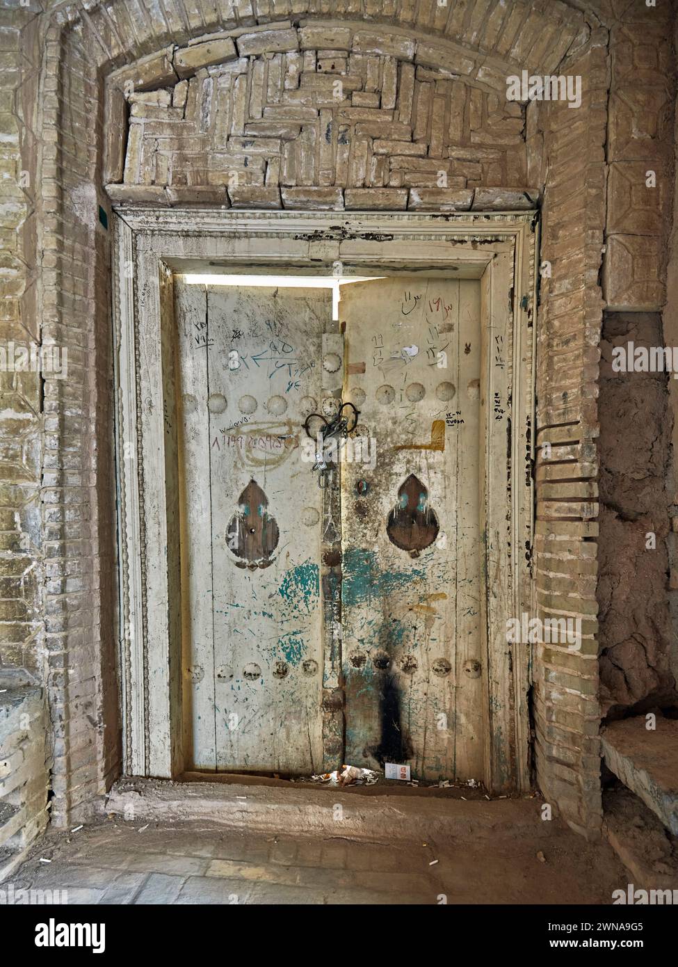 Porte en bois fermée d'un bâtiment abandonné dans la vieille ville de Yazd, Iran. Banque D'Images
