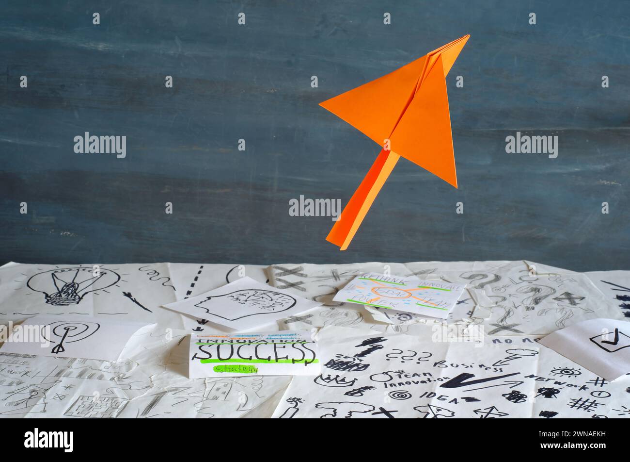 Nouvelles idées pour la transformation de l'entreprise avec des griffonnages et des notes de brainstorming sur papier et un avion de papier décollage, innovation, succès, travail d'équipe et Banque D'Images