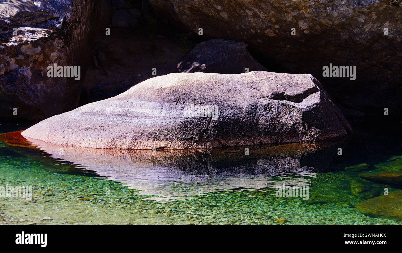Boulder et c'est le reflet dans l'eau. Banque D'Images