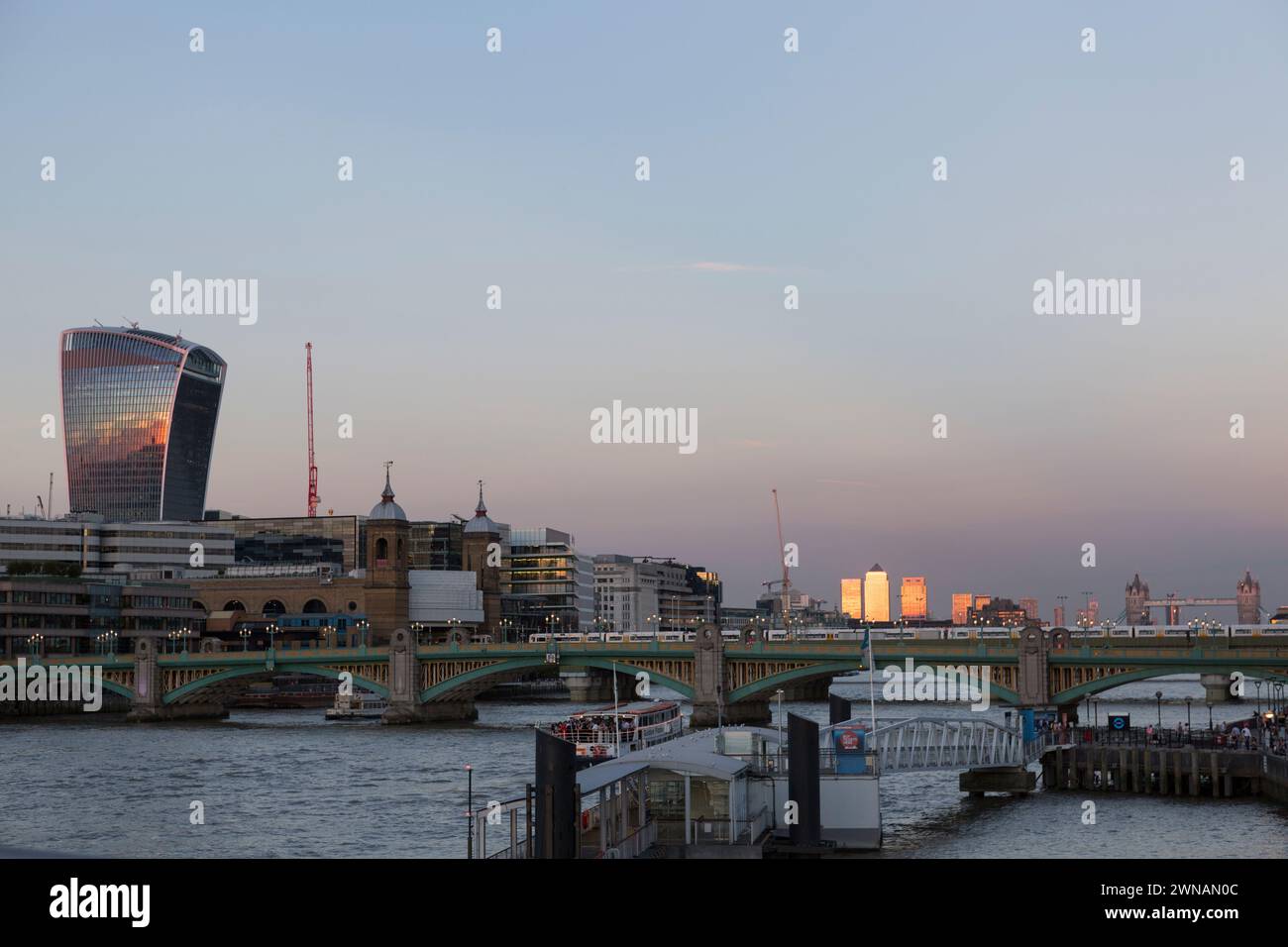 Royaume-Uni, Londres, Canary Wharf avec la lumière du soleil doré et la ville de londres avec le bâtiment Walkie Talkie et Southwark Bridge au premier plan. Banque D'Images