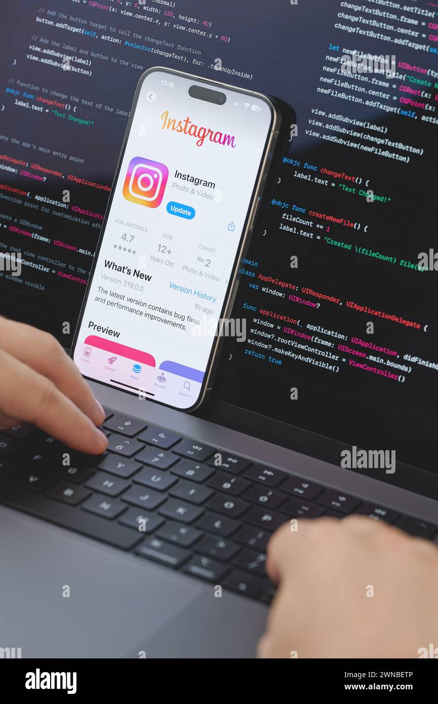 New York, États-Unis - 23 février 2024 : Code pour la nouvelle application Instagram dans l'écran d'ordinateur portable avec les mains sur le clavier Banque D'Images