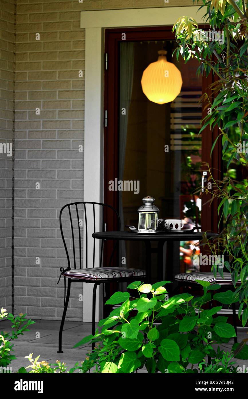 Une petite terrasse d'une maison et une table de café vide Banque D'Images