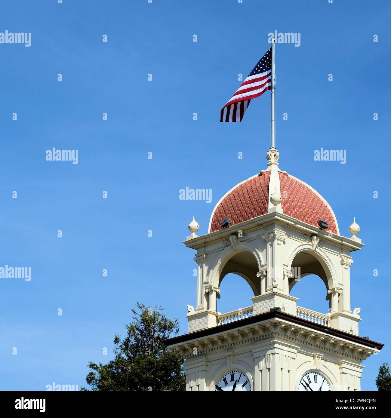 Drapeau américain sur mât de drapeau au sommet de la tour Town Clock, à Pacific Avenue et Water et Front Street dans le centre-ville de Santa Cruz, en Californie. Banque D'Images