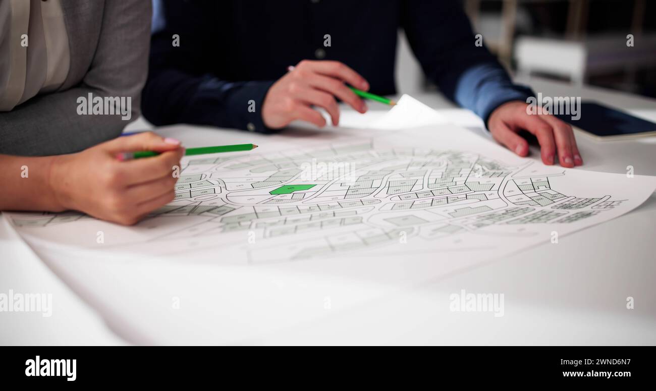 Close-up of Human Hand Holding crayon papier sur la carte du cadastre Banque D'Images