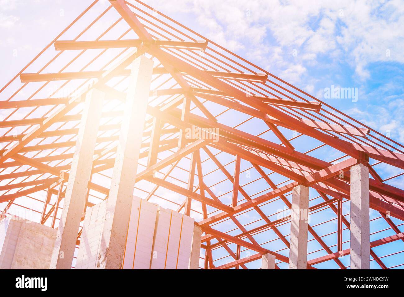 Structure de cadre de toit en acier de la maison de construction au chantier de construction avec des nuages de ciel bleu et la lumière du soleil Banque D'Images