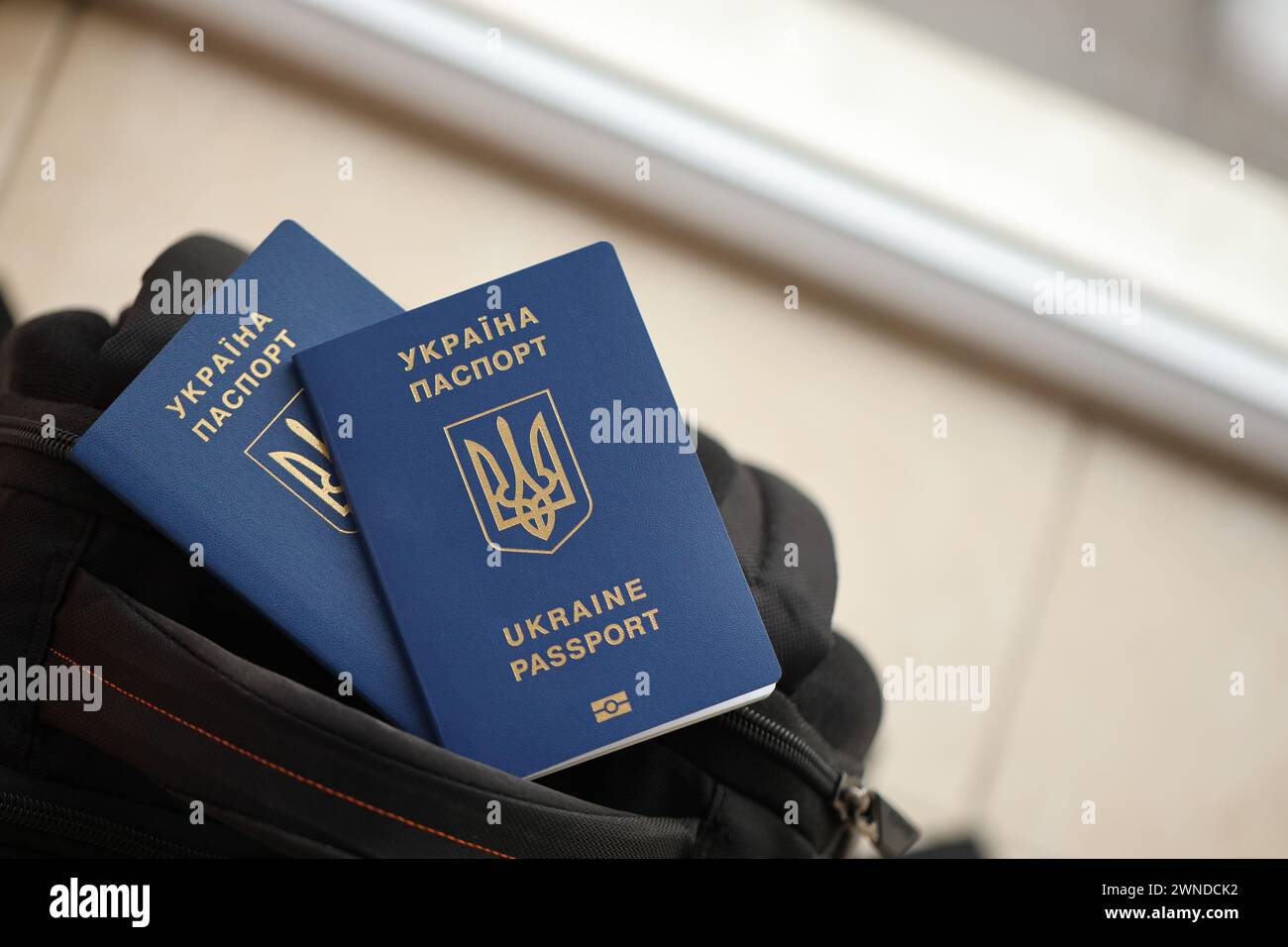 Deux passeports biométriques ukrainiens sur un sac à dos touristique noir se rapprochent Banque D'Images