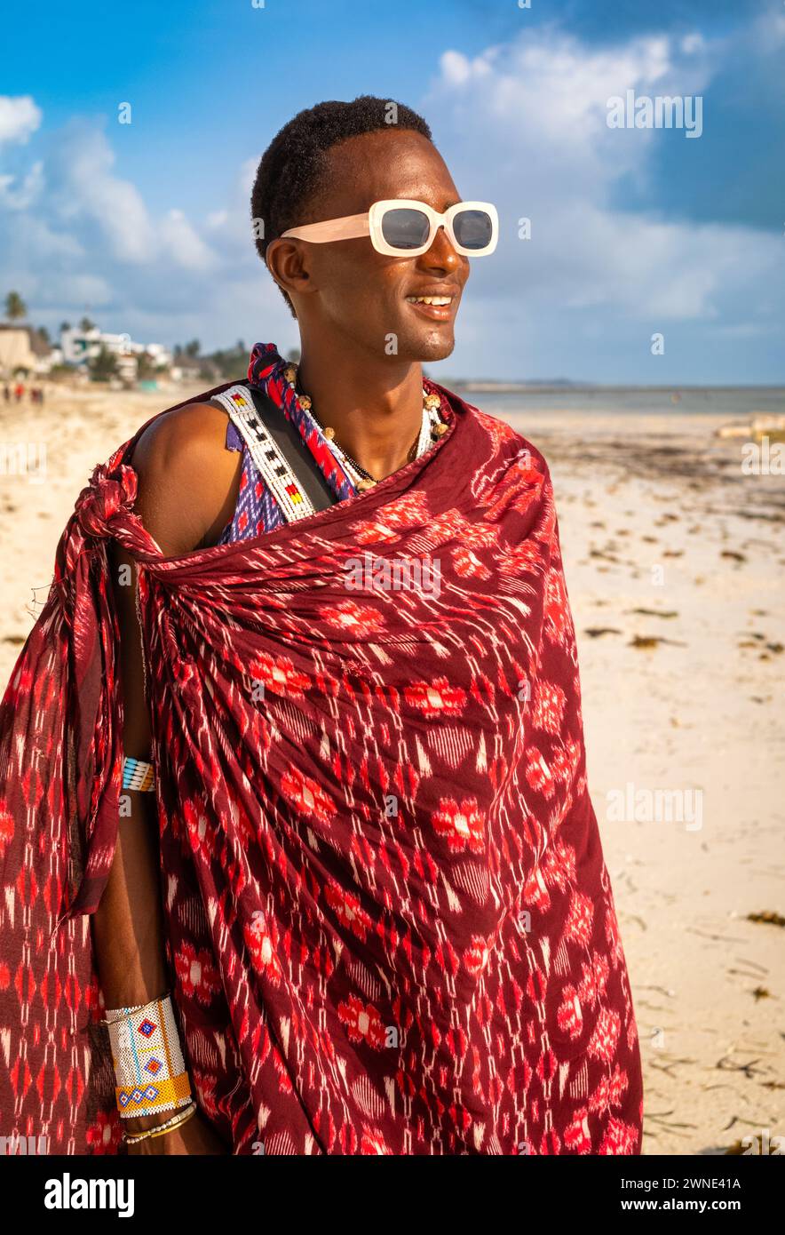Un jeune guerrier Massaï dans un shuka traditionnel sur la plage de Jambiani, Zanzibar, Tanzanie Banque D'Images