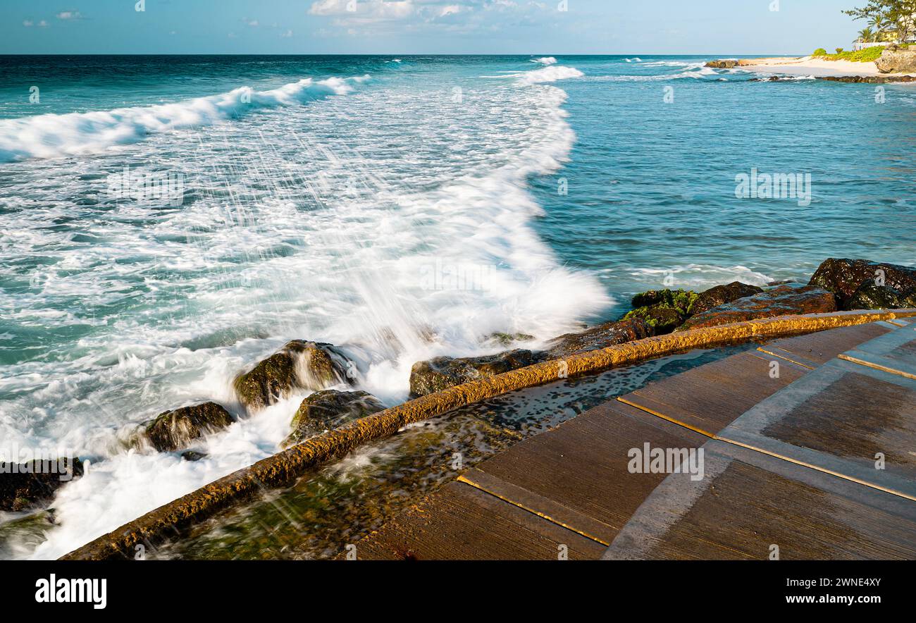 Invitant mer cristalline et surf moussant doucement sur les beaux sables doux de Rockley Beach, Barbade. Banque D'Images