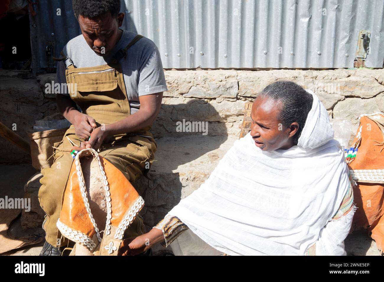 Vieille femme et son fils assis dans la rue travaillant le cuir en Ethiopie. Banque D'Images