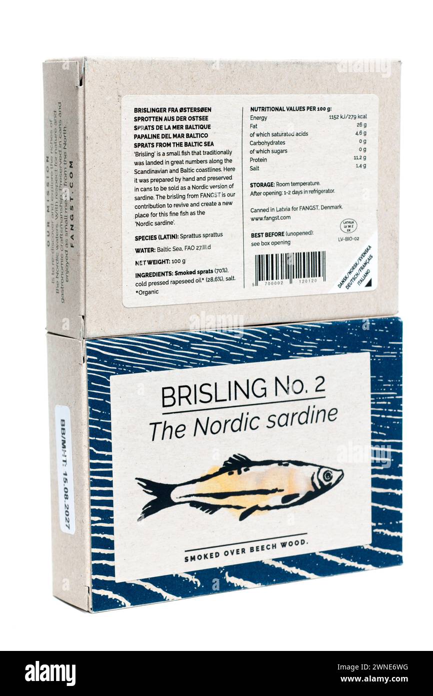 Deux boîtes de sardines Nordick Fangst brisling NO 2 fumées sur du bois de hêtre montrant des valeurs nutritionnelles et des informations Banque D'Images