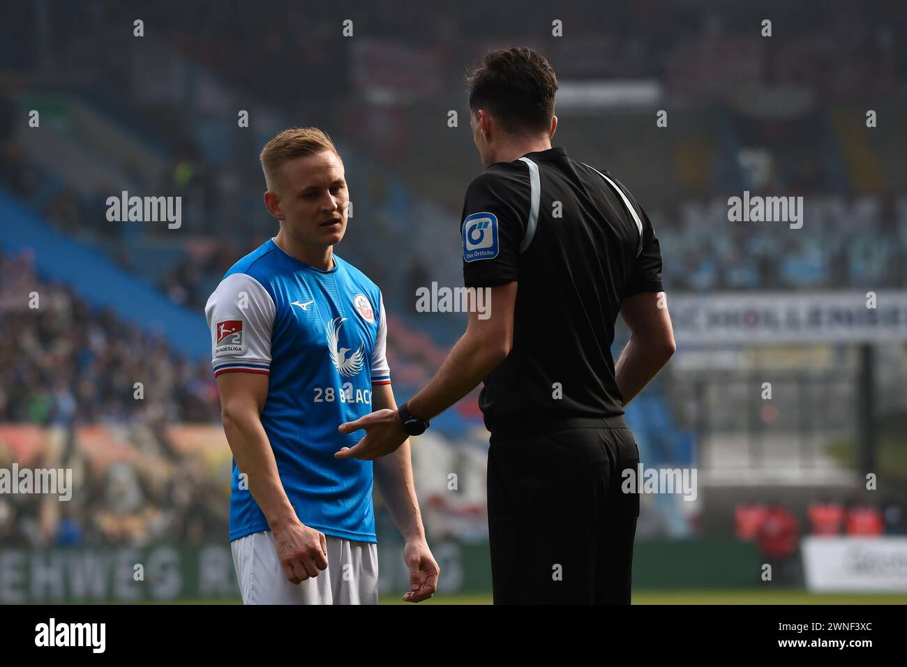 Rostock, Allemagne. 02 mars 2024. Football : Bundesliga 2, Hansa Rostock - 1. FC Kaiserslautern, Journée 24, Ostseestadion. Kai Pröger (gauche-droite) de Rostock et l'arbitre Florian Badstübner discutent d'une situation de match pendant une interruption. Crédit : Gregor Fischer/dpa - REMARQUE IMPORTANTE : conformément aux règlements de la DFL German Football League et de la DFB German Football Association, il est interdit d'utiliser ou de faire utiliser des photographies prises dans le stade et/ou du match sous forme d'images séquentielles et/ou de séries de photos de type vidéo./dpa/Alamy Live News Banque D'Images