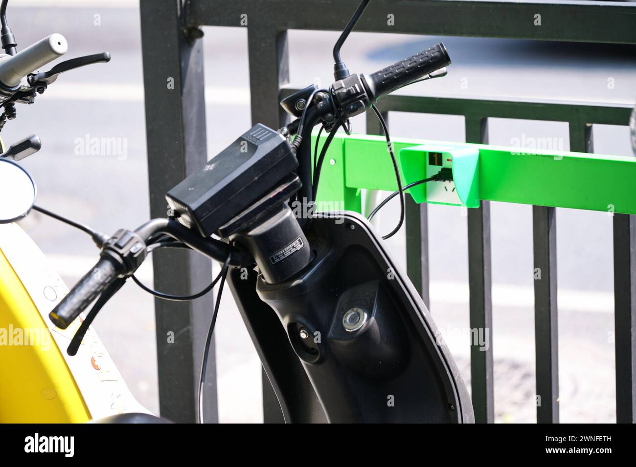 GUANGZHOU, CHINE - 22 février 2024 : scooter électrique avec station de recharge dans une rue de la ville Banque D'Images