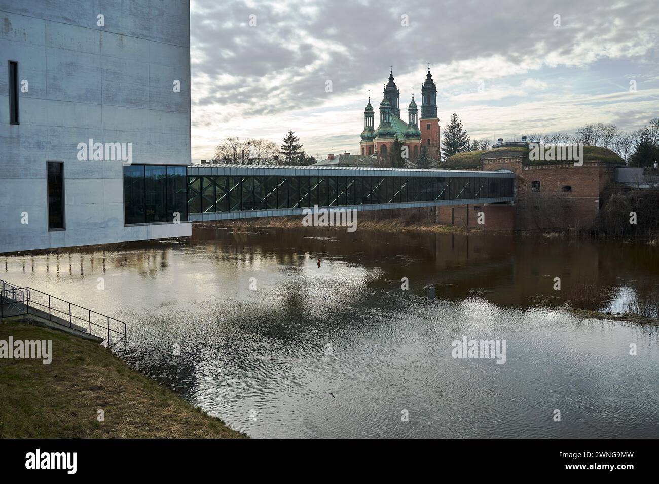 Bâtiment moderne, pont piétonnier et murs défensifs historiques sur la rivière Warta à Poznan, Pologne Banque D'Images