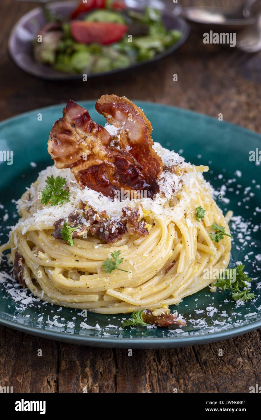 Spaghetti Carbonara avec salade sur bois Banque D'Images