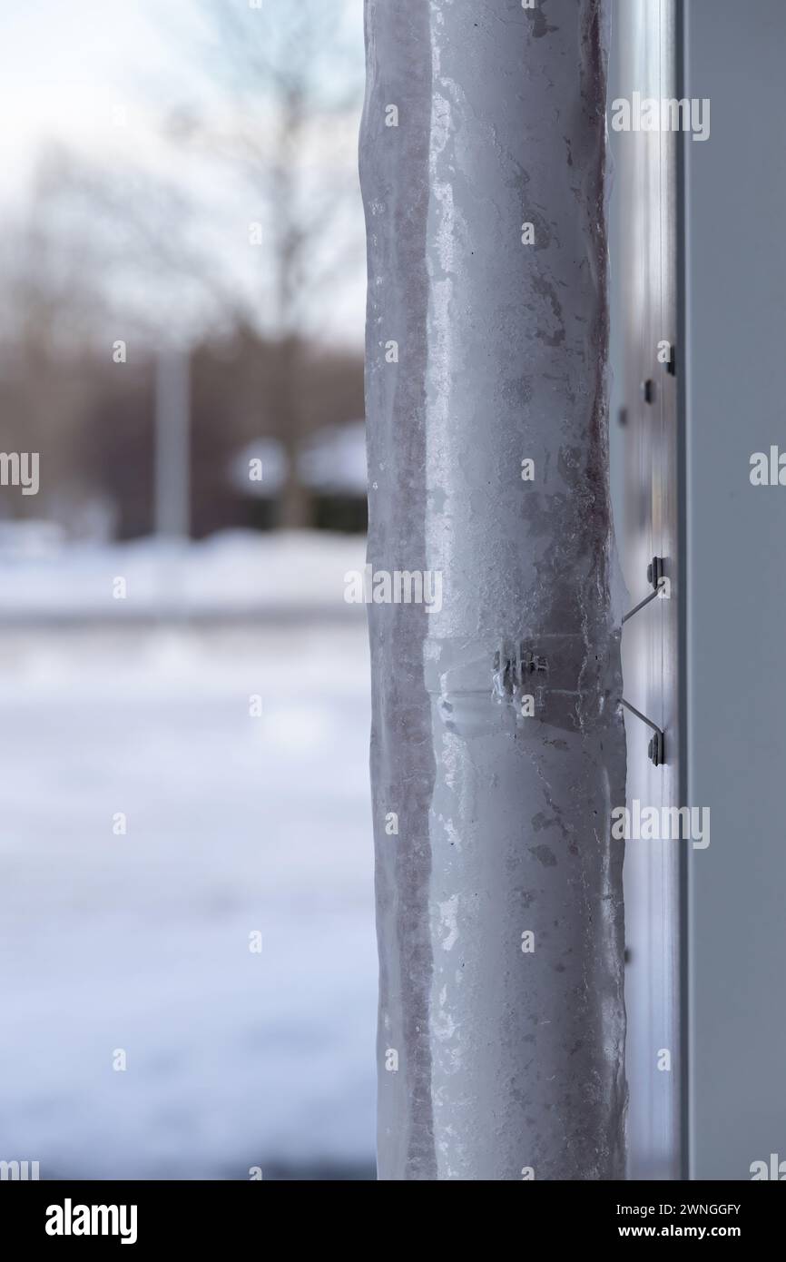 Détail d'une descente d'eau de pluie avec de la glace épaisse autour Banque D'Images