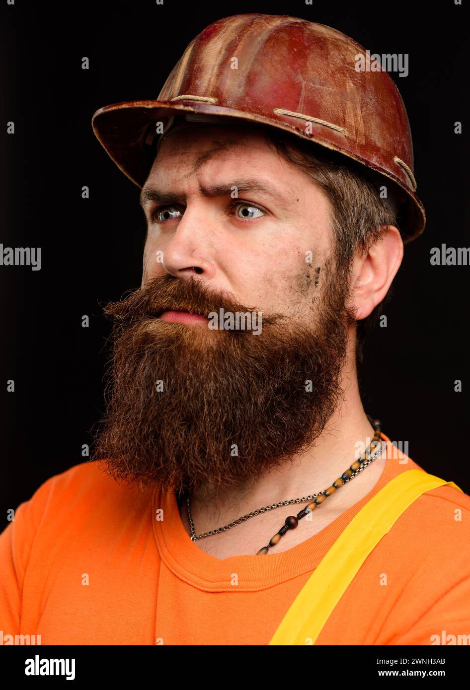 Travailleur industriel ou mécanique dans le casque de sécurité. Homme barbu pensif en casque de construction. Profession, construction et bâtiment - professionnel sérieux Banque D'Images