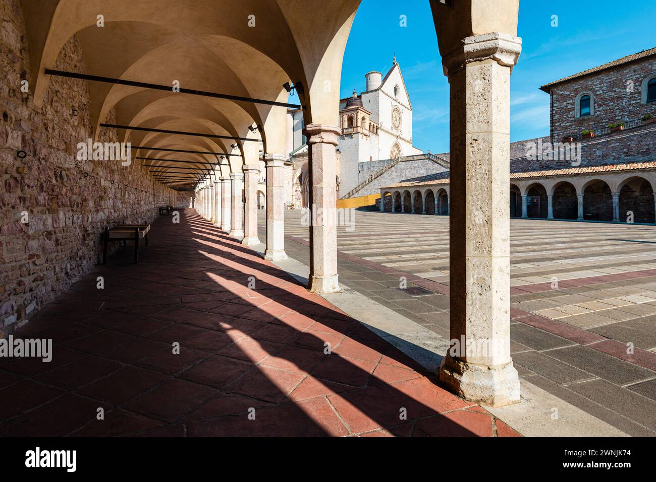 Vue à travers les colonnes sur la basilique Saint François d'assise sous le soleil du matin, Ombrie, Italie Banque D'Images