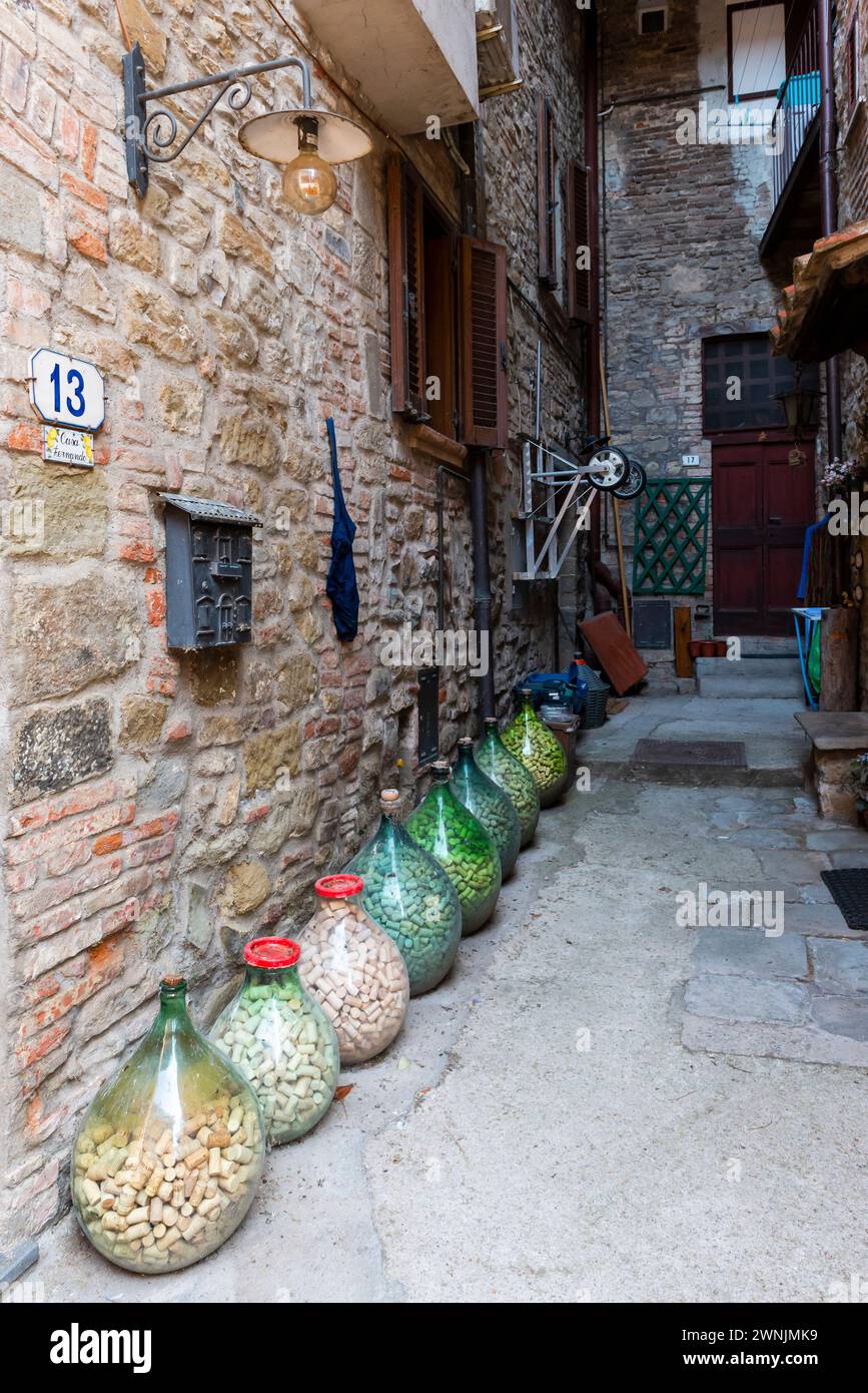 Ventre des bouteilles pleines de bouchons dans une cour dans la vieille ville de Passignano sul Trasimeno, Ombrie, Italie Banque D'Images