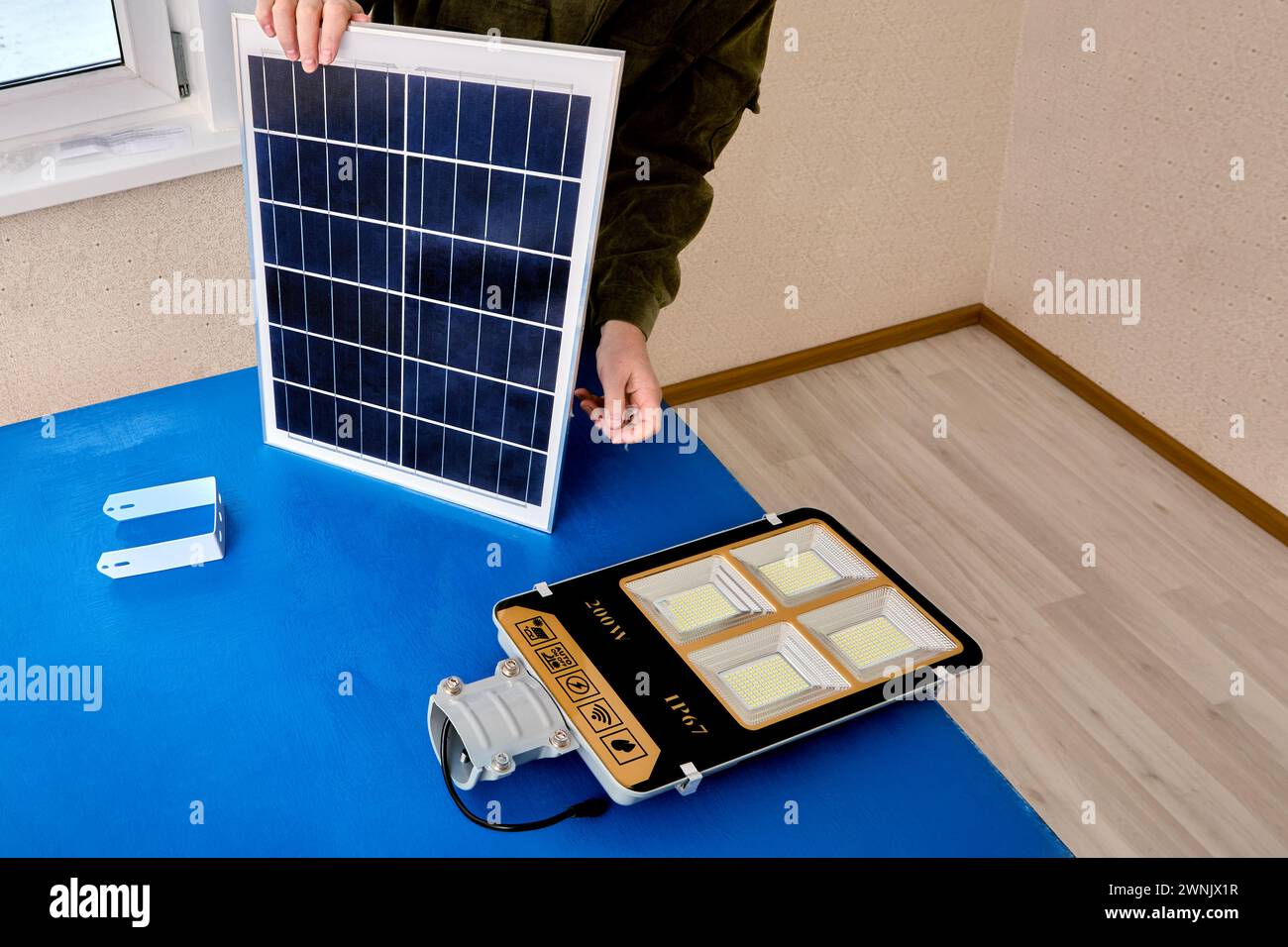 Panneau solaire pour éclairage extérieur LED, assembleur monte le lampadaire sur le support. Banque D'Images