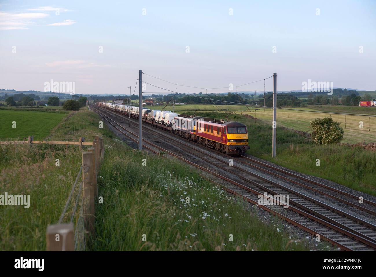 Un train de marchandises DB Cargo transporté par 2 locomotives électriques de classe 90 transportant des véhicules Ford neufs passe devant Plumpton sur la ligne principale de la côte ouest Banque D'Images