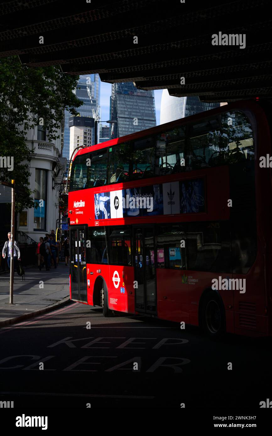 Un bus attrape le soleil du soir alors qu'il se dirige vers London Bridge, Londres, Royaume-Uni. 17 juillet 2023 Banque D'Images