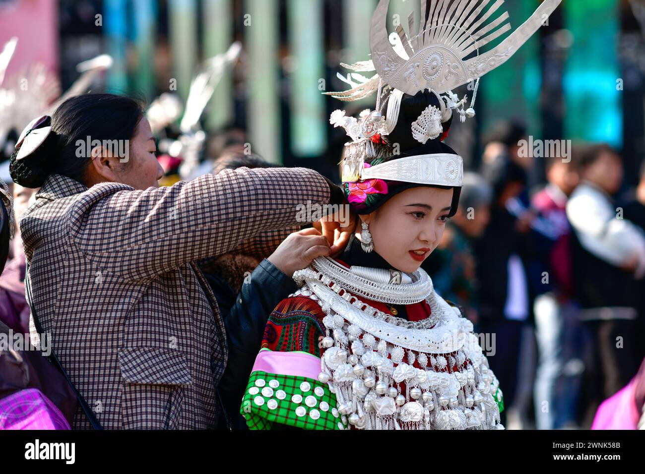 Kaili, province chinoise du Guizhou. 2 mars 2024. Une femme de l'ethnie Miao organise des ornements en argent pour sa fille pendant le festival Gannangxiang à Kaili, Qiandongnan Miao et dans la préfecture autonome de Dong, dans la province du Guizhou au sud-ouest de la Chine, le 2 mars 2024. À Kaili, les Miao de souche locale ont pour coutume d'enfiler leur tenue traditionnelle et de jouer Lusheng, un instrument de musique traditionnel, pour se réjouir du festival annuel de Gannangxiang, une célébration historique dans la province de Guizhou. Crédit : Yang Wenbin/Xinhua/Alamy Live News Banque D'Images