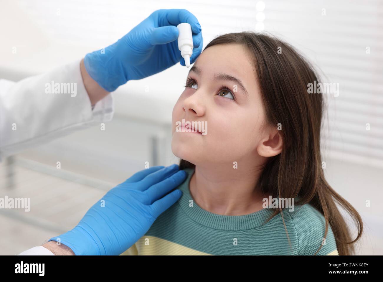 Docteur appliquant des gouttes médicales dans l'oeil de la fille à l'intérieur Banque D'Images