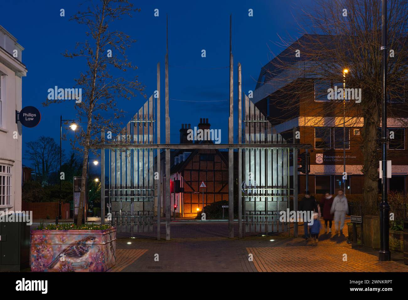 Les portes triomphales illuminées dans la soirée à l'entrée du centre-ville de Basingstoke London Road - acier forgé peint en graphite noir. ROYAUME-UNI Banque D'Images