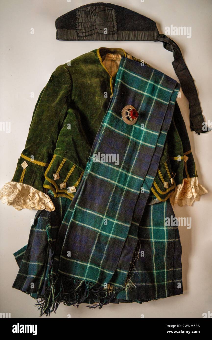 Une tenue de clan vintage de quatre ans, environ 1910, tartan inconnu avec broche écossaise, bonnet Glengarry et tartan Sash Banque D'Images