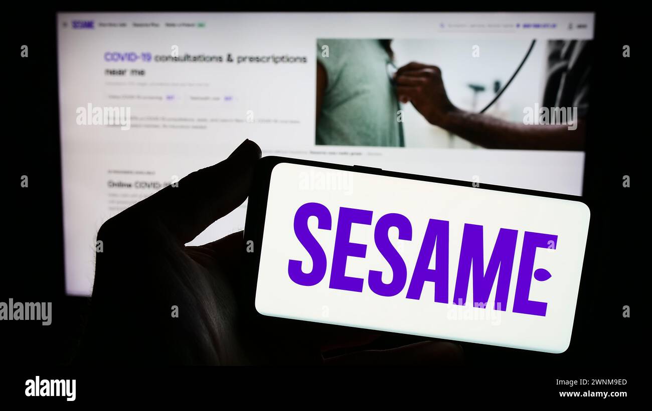 Personne tenant un smartphone avec le logo de la société américaine Sesame Inc du marché des soins de santé en face du site Web. Concentrez-vous sur l'affichage du téléphone. Banque D'Images