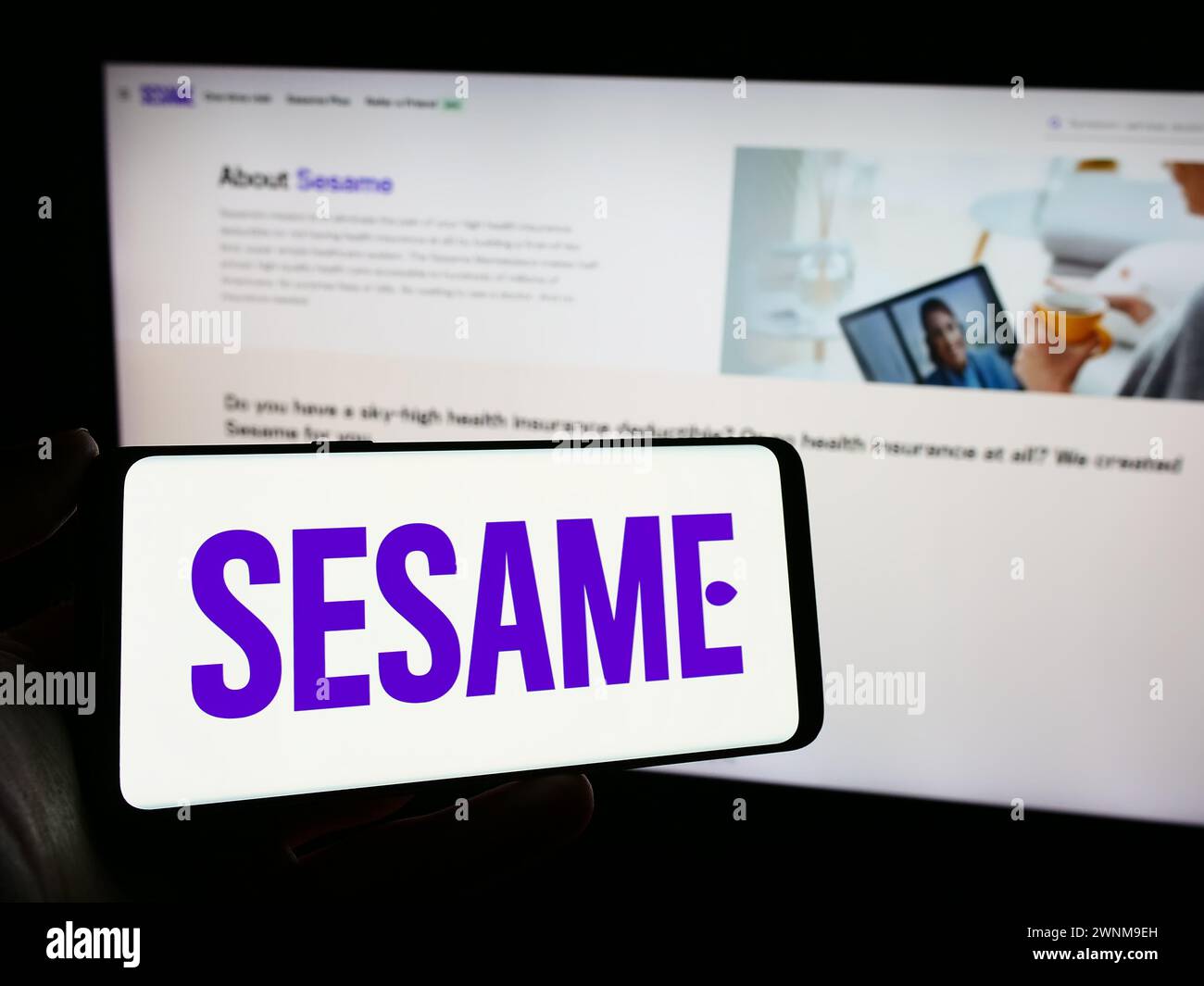 Personne tenant le téléphone portable avec le logo de la société américaine de marché de soins de santé Sesame Inc en face de la page Web. Concentrez-vous sur l'affichage du téléphone. Banque D'Images