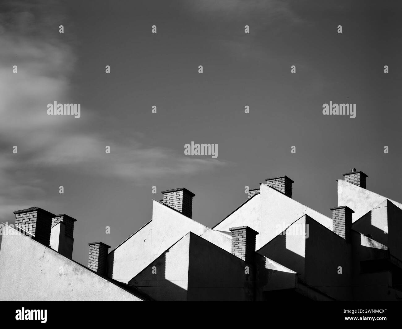 Montant au-dessus. Construire des cheminées en briques sur le toit contre la vaste skyline.Noir et blanc, monochrome. Banque D'Images