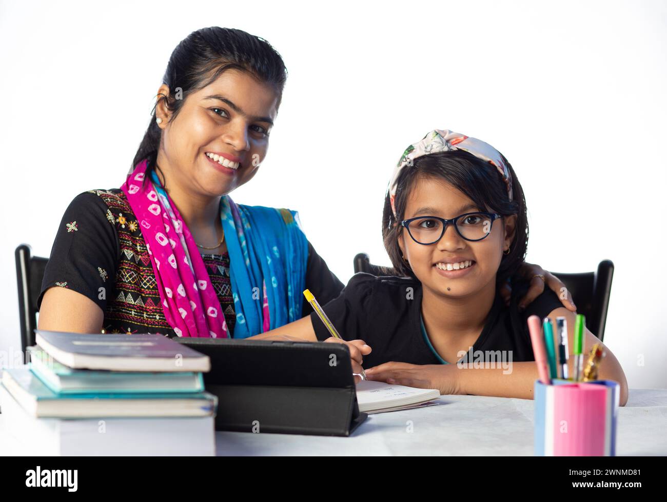 Une étudiante indienne étudiant avec tablette à côté de sa mère, professeur : concept de professeur privé Banque D'Images