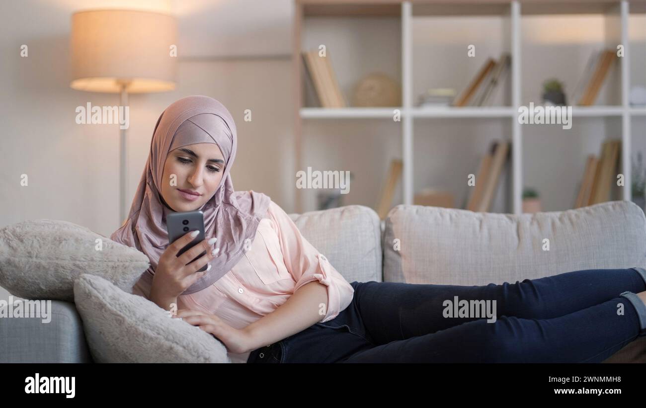 Téléphone mobile de loisirs navigation femme canapé à la maison Banque D'Images