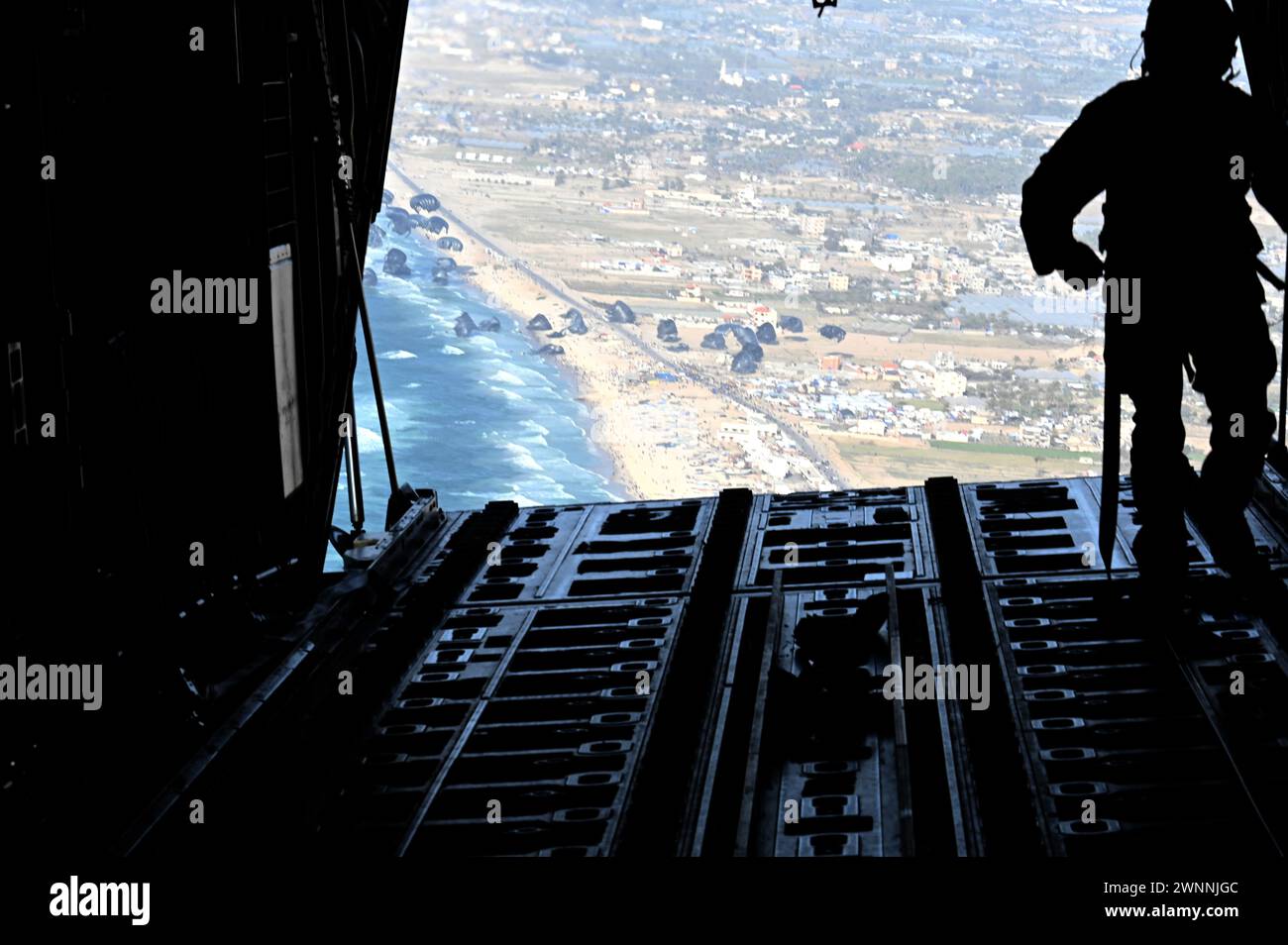 Bande de Gaza, Israël. 02 mars 2024. Un capitaine de chargement de l'US Air Force regarde 66 palettes d'aide humanitaire larguées par un avion C-130J Super Hercules de l'USAF sur des réfugiés palestiniens piégés par la guerre israélienne contre le Hamas, le 2 mars 2024 au-dessus de la bande de Gaza, Territoires palestiniens. Un total de 38 000 MRE ont été largués de trois avions américains. Crédit : TSGT. Christopher Hubenthal/US Airforce photo/Alamy Live News Banque D'Images