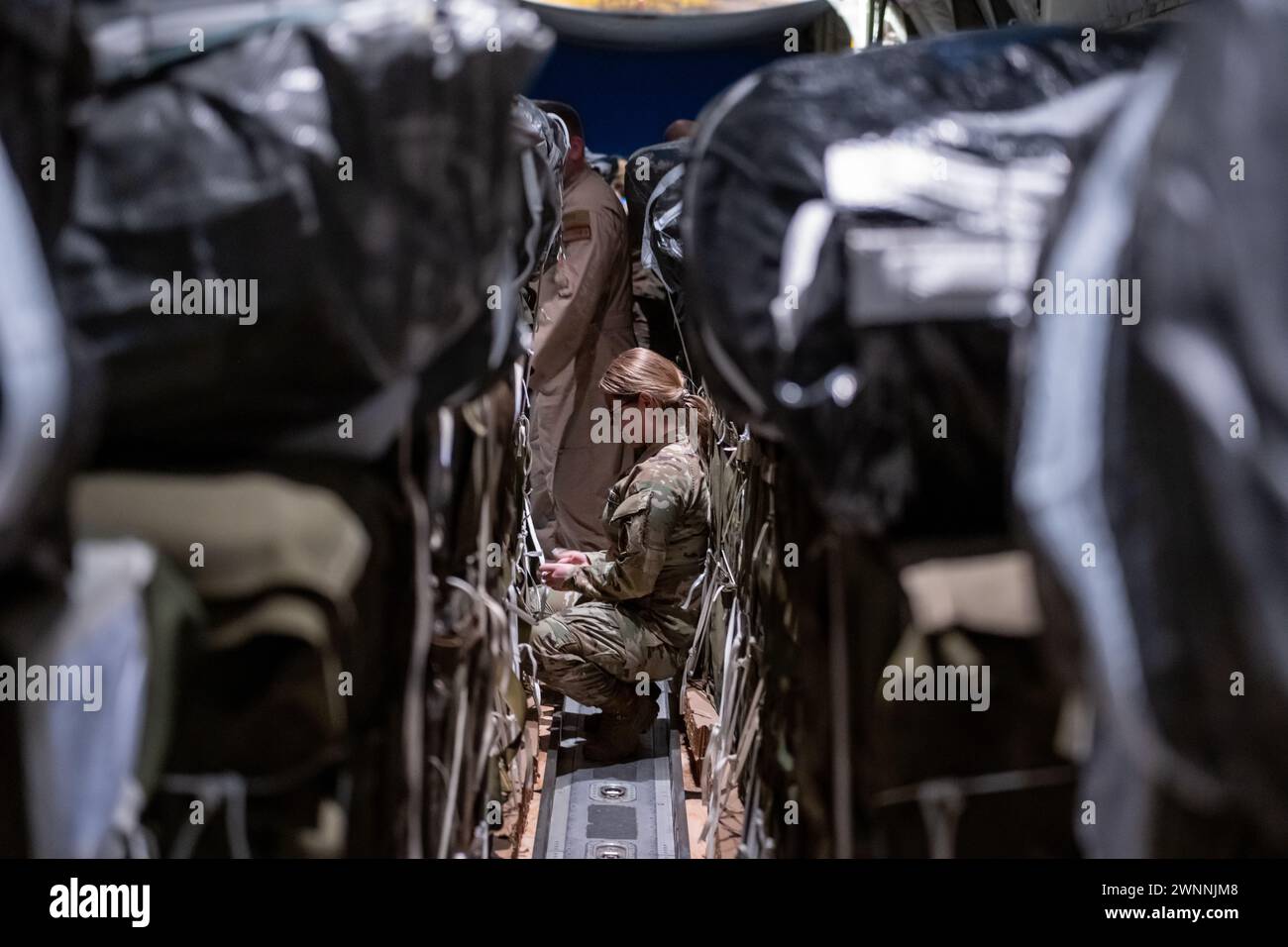 Azraq, Jordanie. 01 mars 2024. Un soldat de l'armée américaine sécurise des sangles sur des palettes d'aide humanitaire dans la soute d'un avion C-130J Super Hercules de l'US Air Force à la base aérienne Muwaffaq Salti, le 1er mars 2024 à Azraq, gouvernorat de Zarqa, Jordanie. L’aide alimentaire sera larguée par voie aérienne aux réfugiés palestiniens pris au piège de la guerre israélienne contre le Hamas. Crédit : TSGT. Christopher Hubenthal/US Airforce photo/Alamy Live News Banque D'Images