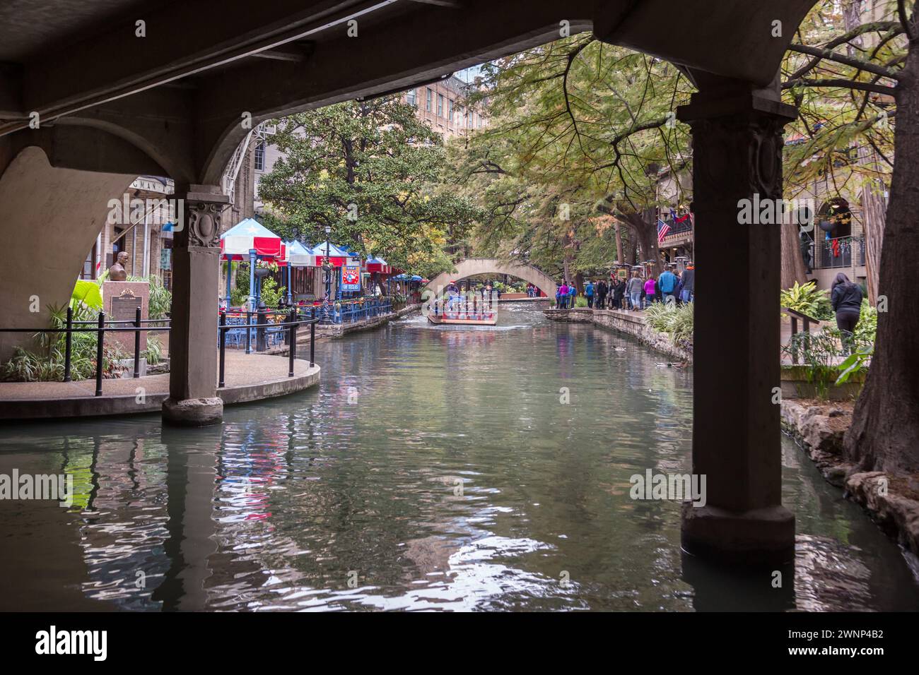 Touristes et habitants marchant et chevauchant un bateau de croisière Rio San Antonio le long de la promenade de la rivière dans le centre-ville de San Antonio, Texas Banque D'Images