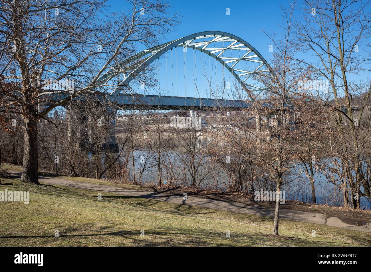 Par une journée de printemps ensoleillée, le Birmingham Bridge s'étend gracieusement sur la rivière Allegheny, encadré par un ciel bleu impeccable, vu depuis le T de Pittsburgh Banque D'Images